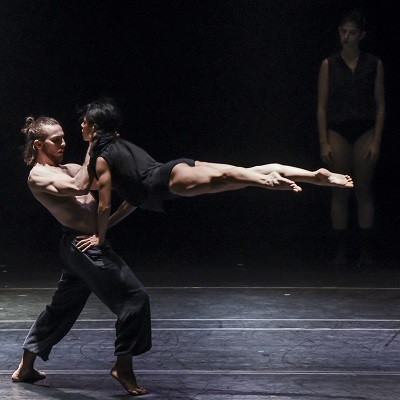 Couple of dancers in dynamic pose. Young man and woman in black suits  performing modern dance. Art dance studio Stock Photo - Alamy